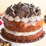 Easy chocolate oreo cake (layer cake) with cookies and cream buttercream frosting and chocolate ganache on white cake stand.