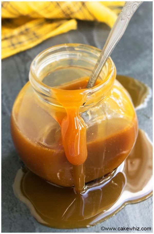 Homemade Caramel Cream Dripping From Glass Jar With Spoon 
