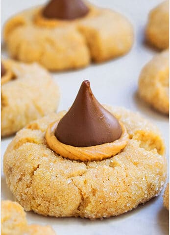 Easy Peanut Butter Blossoms With Hershey's Kisses on White Marble Background.