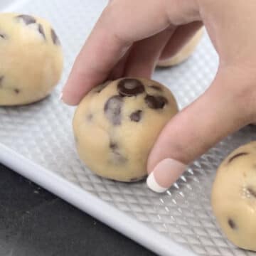 Dough ball being placed on a tray.
