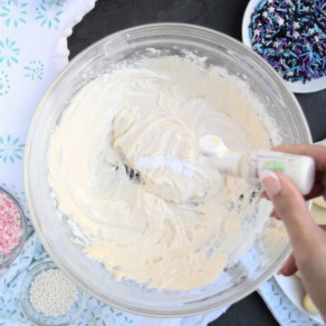 White food coloring being added to icing. 