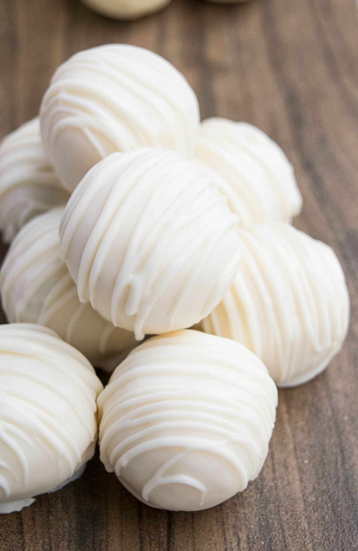 Pile of creamy vanilla truffles on wood background. 