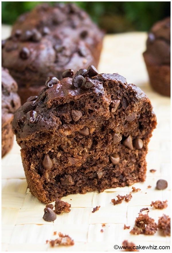Healthy Double Chocolate Muffins Cut in Half on Light Brown Background. 