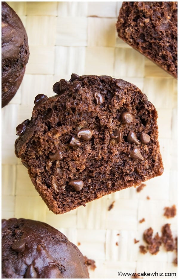 Chocolate Muffin Cut in Half on Light Brown Background. 