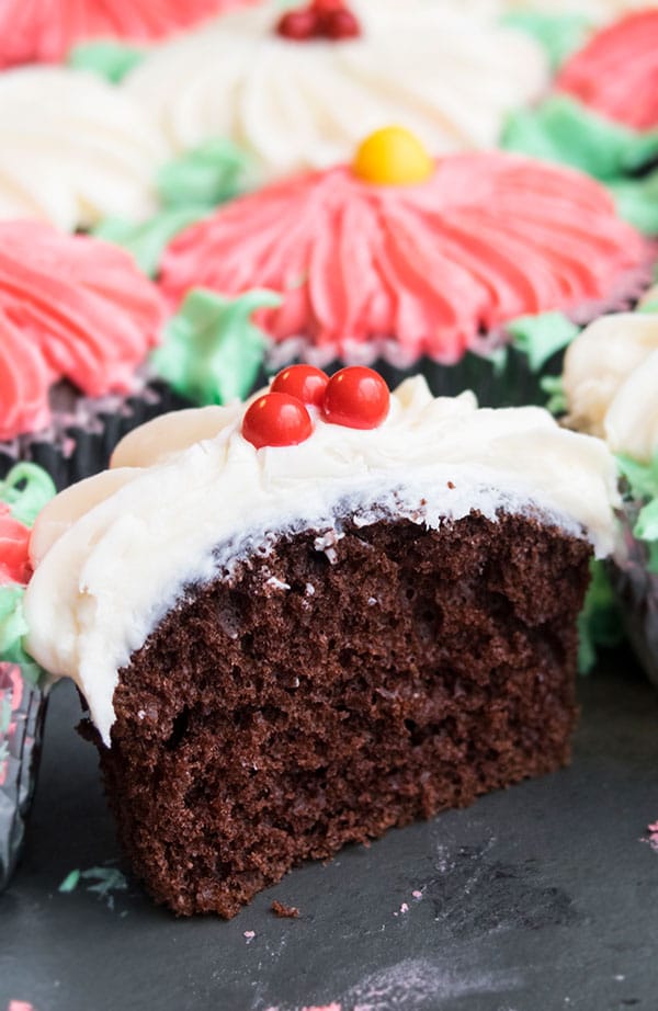 Partially Eaten Chocolate Cupcake With Vanilla Icing on Black Background