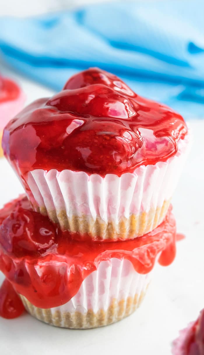 Easy No Bake Mini Strawberry Cheesecake Cupcakes With Graham Cracker Crust Stacked on White Dish.