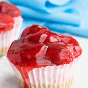 Easy No Bake Mini Strawberry Cheesecake Cupcakes on White Marble Background.