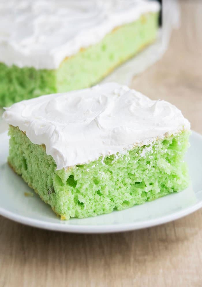 Cake Mix Cake with Pistachios and Whipped Cream on White Plate