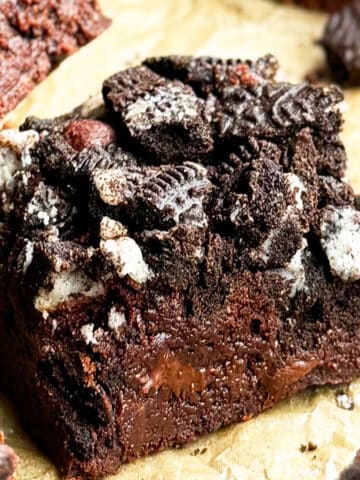 Slice of Easy Fudgy Chocolate Oreo Brownies on Brown Parchment Paper.