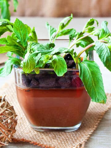 Easy Mini Chocolate Pudding Pots or Dirt Pudding Cups With Oreos and Fresh Mint on Rustic Brown Background.