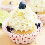 Best easy soft and moist frosted lemon blueberry cupcakes with pink polka dot liners on light brown background.
