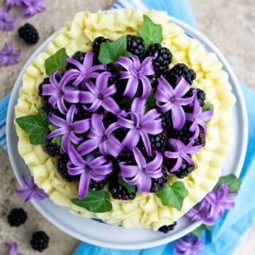 Closeup shot of flower, leaf and berry decoration on top of cake.