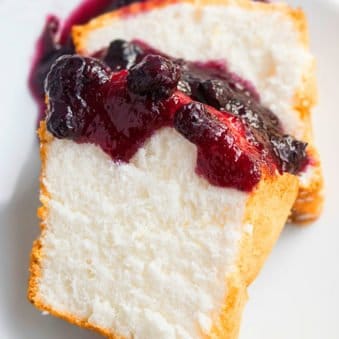 Slices of Angel Food Cake With Berry Topping on White Dish.