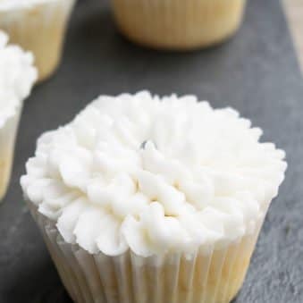 Easy White Wedding Cupcakes With Buttercream Frosting on Rustic Gray Background.