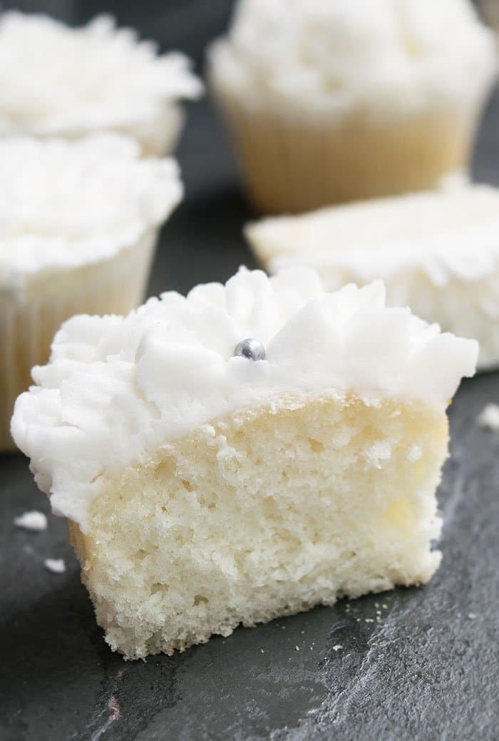 Partially Eaten White Cupcake on Rustic Gray Background. 