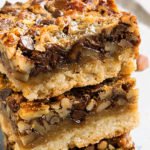 Stack of Easy Chocolate Pecan Pie Bars With No Corn Syrup on Black Dish