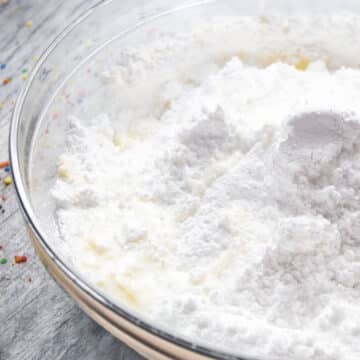 Milk added to other ingredients in glass bowl. 