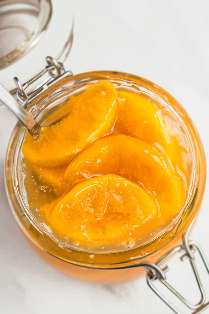 Homemade Pie Filling in Glass Jar With Silver Spoon on White Marble Background. 