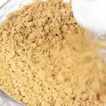 Crumbly dough in glass bowl.