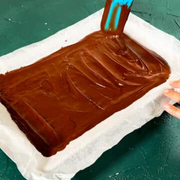 Melted chocolate spread in a pan lined with parchment paper. 