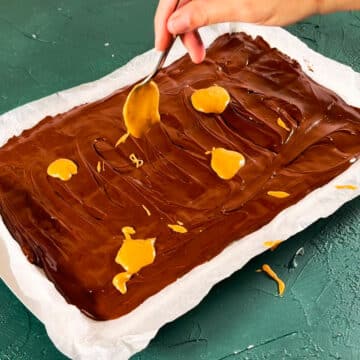 Spoonfuls of melted peanut butter added on top of melted chocolate.