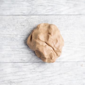 Chilled ball of cookie dough on sheet of wax paper. 