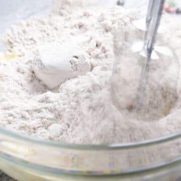 Cake mix powder added to other wet ingredients in glass bowl. 
