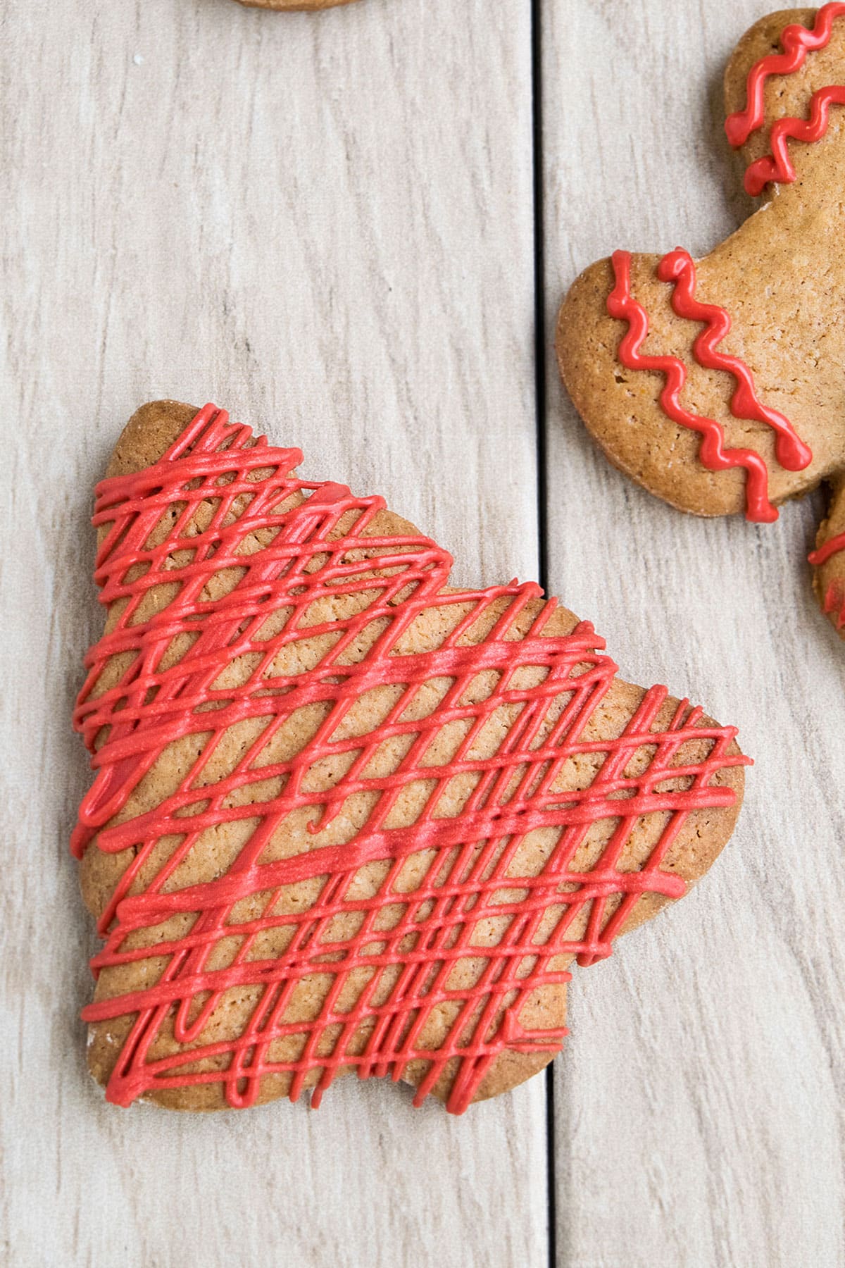 Cut Out Tree Cookies Decorated With Red Royal Icing on Wood Background. 