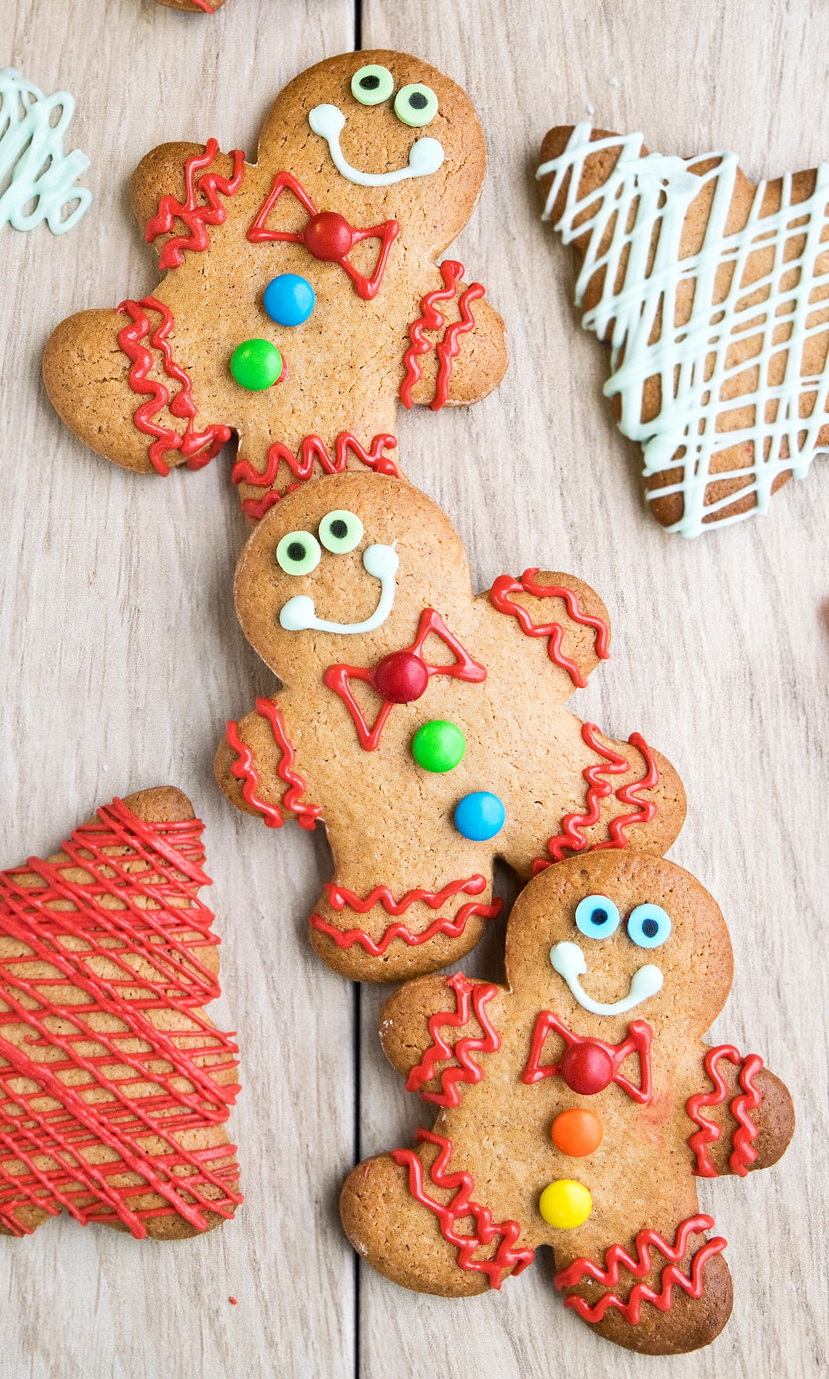 Decorated Cut Out Gingerbread Cookies With Cake Mix on Wood Background. 