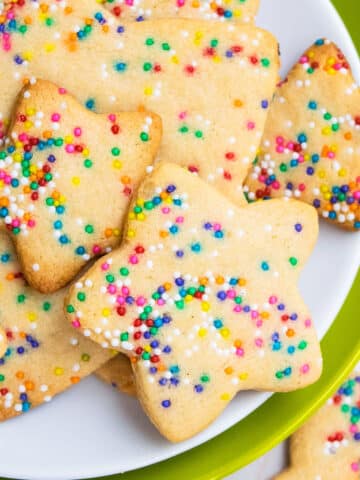 Easy Star Shaped Cut Out Funfetti Cookies With Rainbow Sprinkles on White and Green Dish.