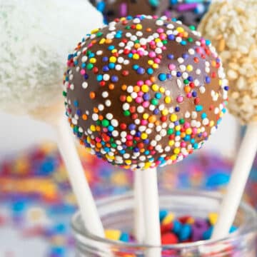 Easy Homemade Cake Pops Covered in Melted Chocolate and Sprinkles in Glass Jar.