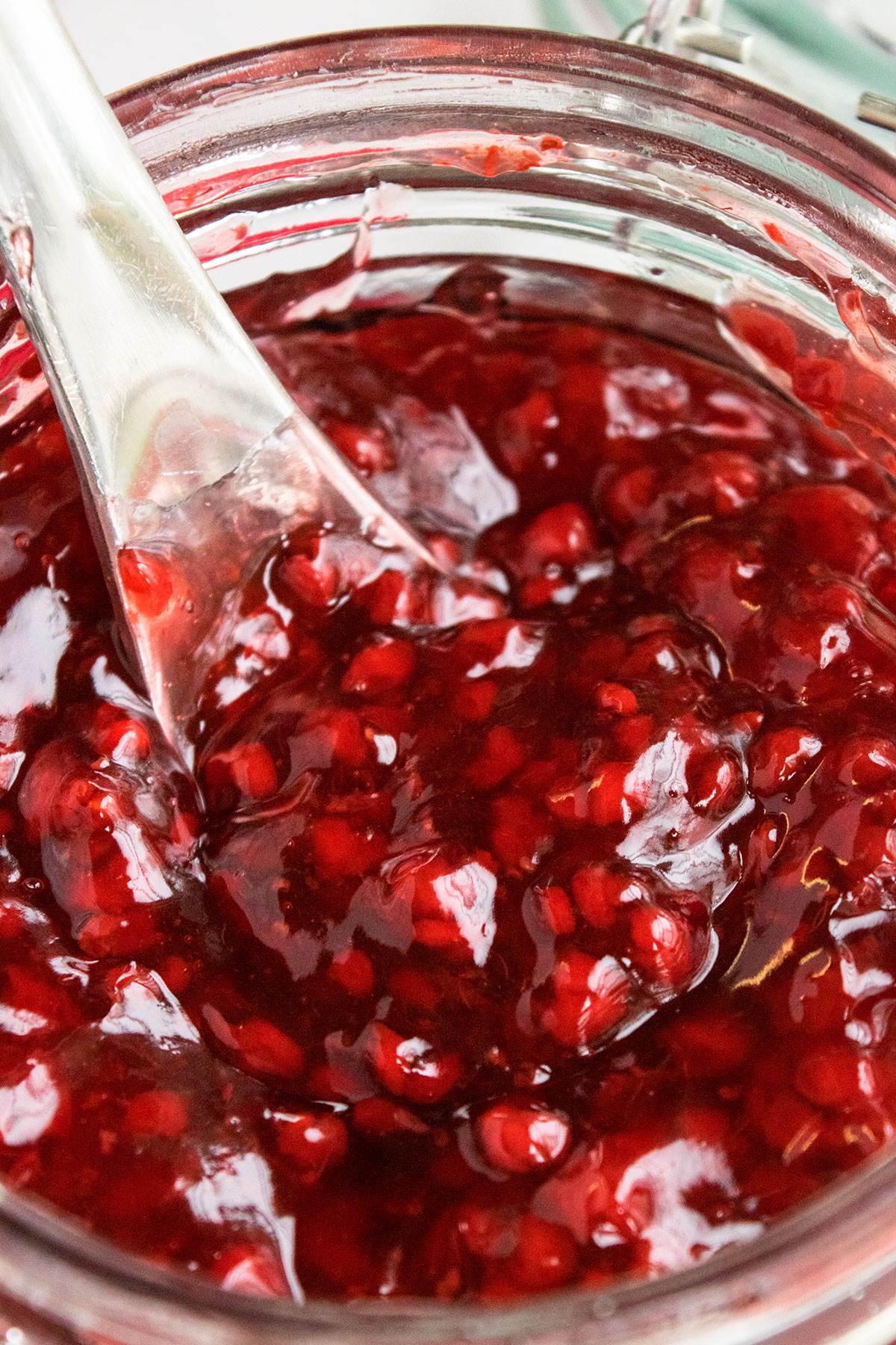 Closeup shot of spoonful of filling in glass jar. 