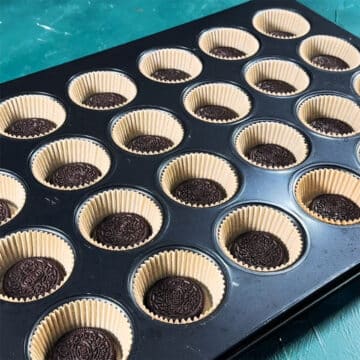 Baking tray with liners and Oreo cookies.  