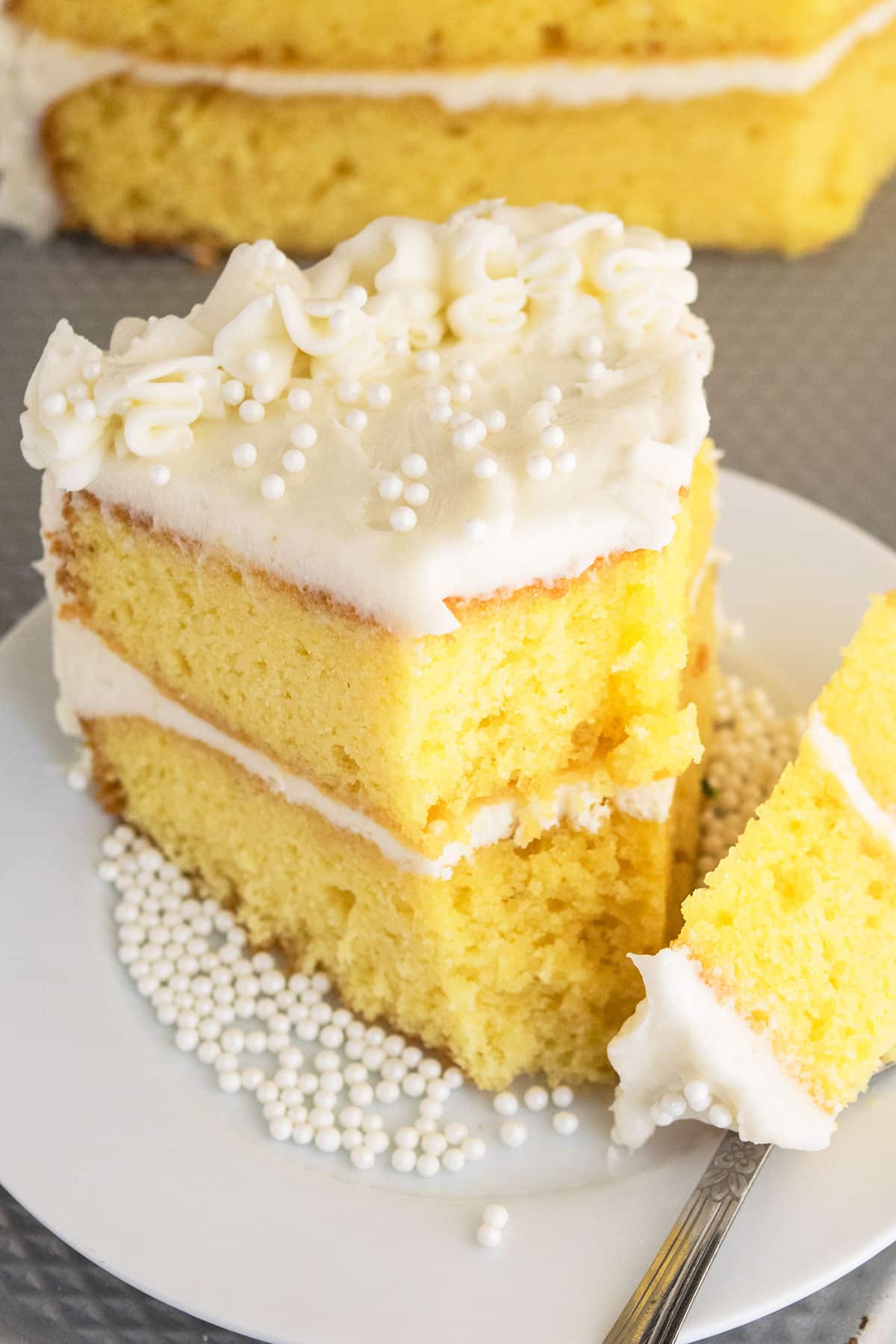Partially eaten cake on white cake dish. 