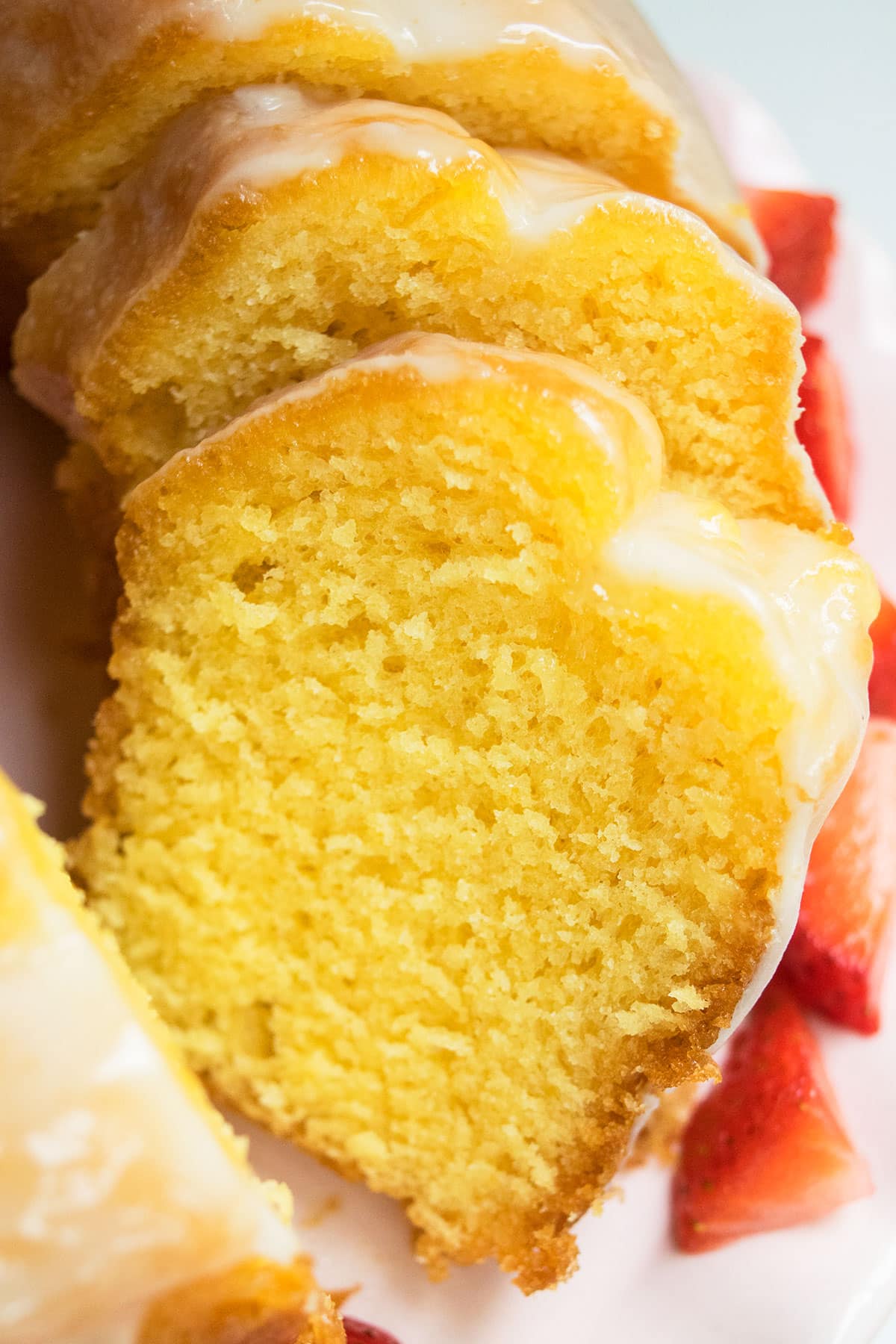 Easy lemon bundt cake with cake mix and topped off with lemon glaze on white dish. 