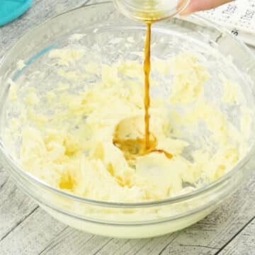 Vanilla extract being added to mixture in glass bowl. 