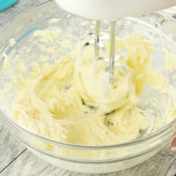 Ingredients being mixed together in a glass bowl. 