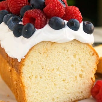 Best Cream Cheese Pound Cake With Topping of Whipped Cream and Fresh Berries.