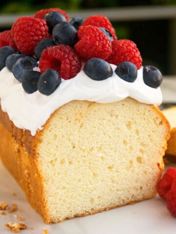 Best Cream Cheese Pound Cake With Topping of Whipped Cream and Fresh Berries.