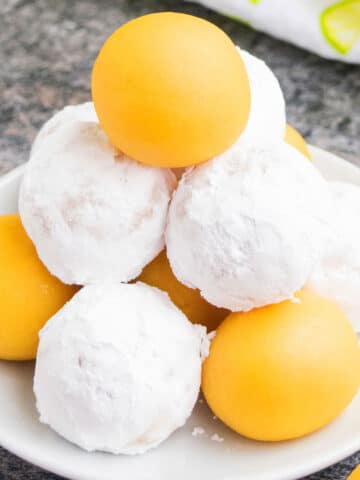 Tower of Lemon Cake Balls or Cake Truffles on white dish where Some are Coated in Powdered Sugar.