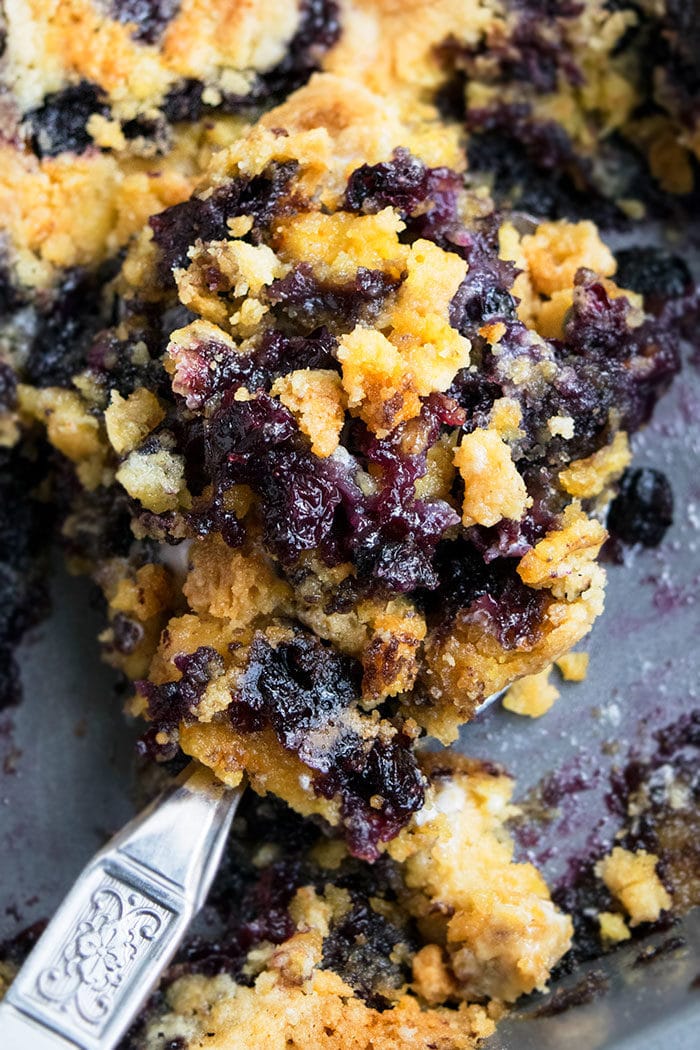 Spoonful of Blueberry Dump Cake in Gray Pan