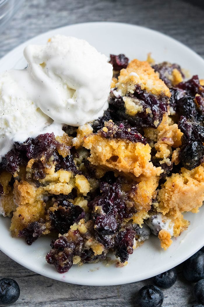 Easy Blueberry Cobbler Dump Cake With Cake Mix Served in White Plate With Vanilla Ice Cream