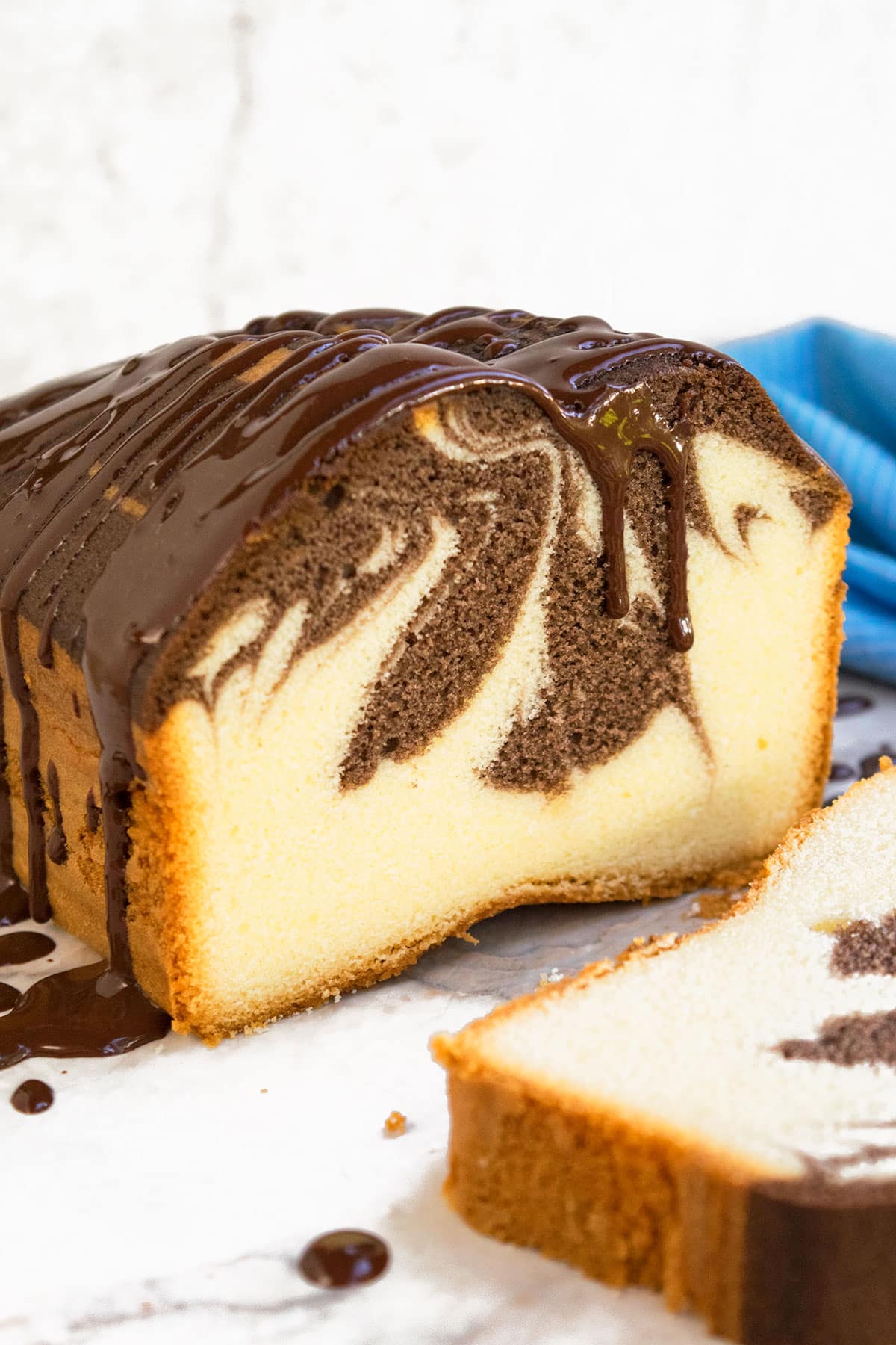 Easy Marble Cake Loaf With Chocolate Ganache on White Dish.