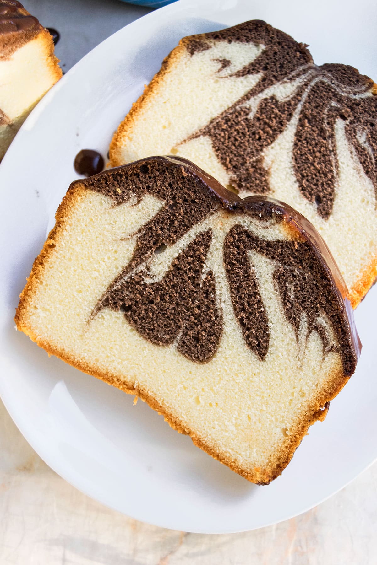 Slices of chocolate swirl pound cake on white dish.