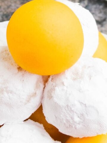 Tower of Lemon Cake Balls or Cake Truffles- Some Coated in Powdered Sugar.