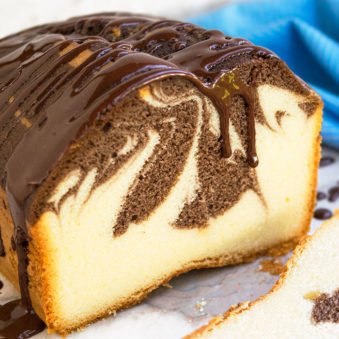 Easy Marble Cake From Scratch With Chocolate Ganache Topping on White Marble Background.