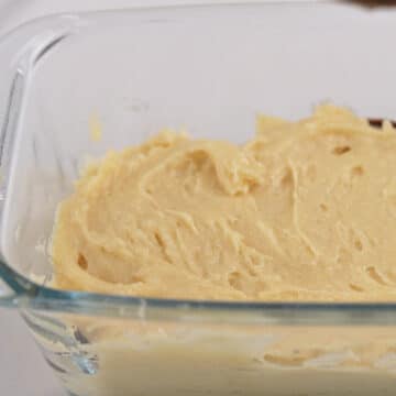 Vanilla cake batter spread in a loaf pan.