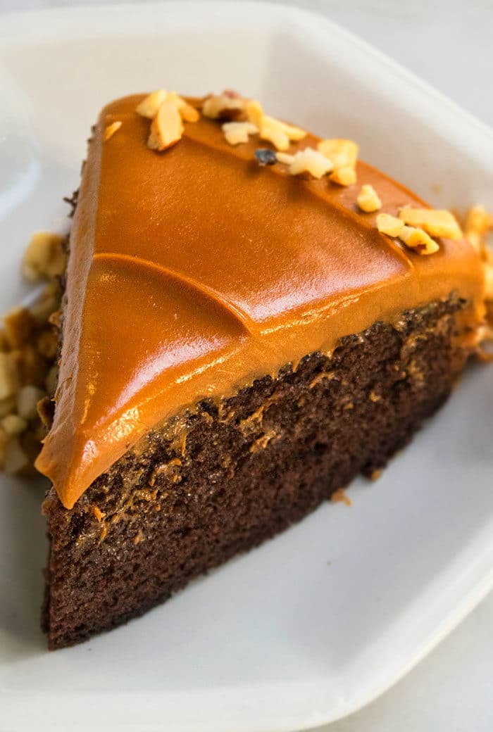 Slice of Chocolate Caramel Cake From Scratch on White Dish. 