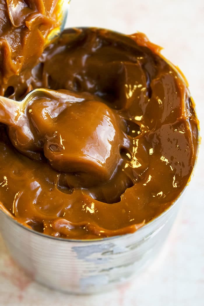 Can of Homemade Dulce De Leche With Condensed Milk on White Marble Background. 