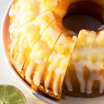 Best easy homemade 7 Up cake with cake mix box and lemon glaze made in bundt pan on white dish and cut into slices.